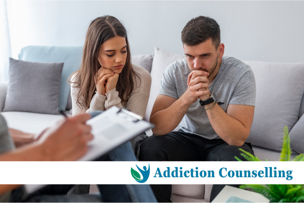 A couple actively participating in an addiction counselling session in a therapist's office.